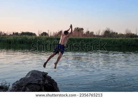 A young man swimming in the Euphrates River in Deir ez-Zor, Syria, in the summer