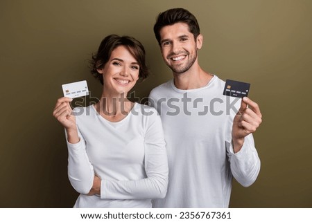 Photo of attractive positive people wear white trendy clothes hand hold plastic bank card buy online isolated on brown color background