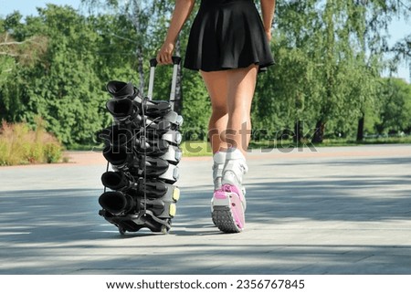 Woman with kangoo jumping boots on hand trolley outdoors, closeup