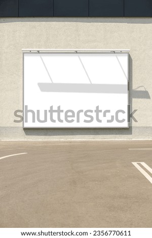 Billboard mockup. Blank advertising poster in frame mounted on building exterior wall with shadow effect. No people. Vertical image.