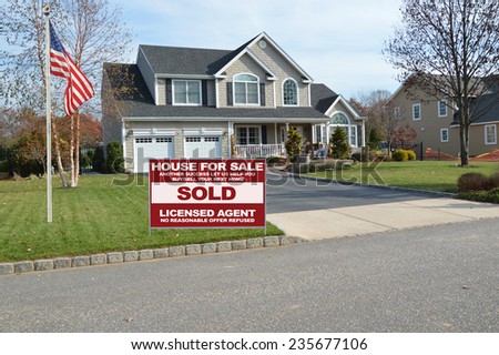 Real Estate sold (another success let us help you buy sell your next home) sign curbside Suburban McMansion home autumn day residential neighborhood USA