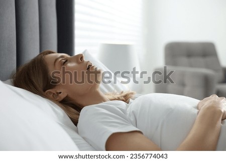 Woman snoring while sleeping in bed at home Royalty-Free Stock Photo #2356774043