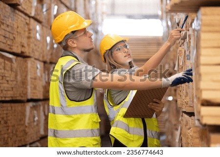 Young female and male workers in a factory for the production of furniture, wood factory. Inspecter factory worker holding clipboard checking quality of wooden products at import export wood warehouse Royalty-Free Stock Photo #2356774643