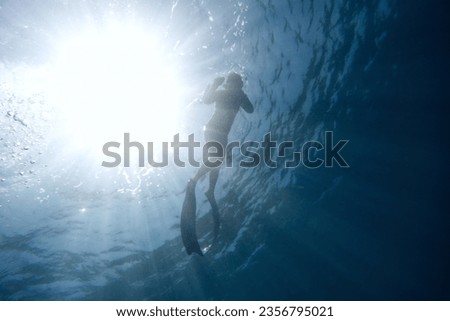 Underwater sunlight and floating people