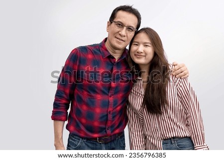 Portrait of happy Asian father with young girl standing isolated over white background, Father wraps his arms around his daughter's shoulders Royalty-Free Stock Photo #2356796385