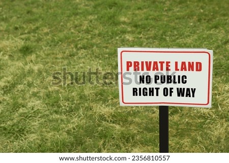 Sign with text Private Land No Public Right Of Way on green lawn