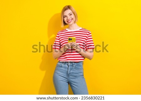 Photo of cheerful lovely girl wear trendy summer clothes buy device iphone samsung isolated on vibrant yellow color background
