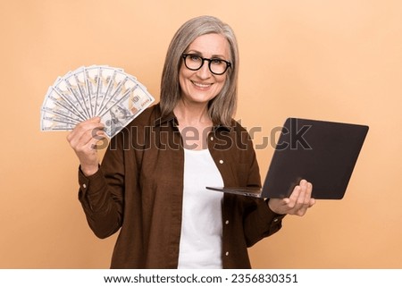 Photo of positive nice person use netbook arm hold dollar bills banknotes isolated on beige color background