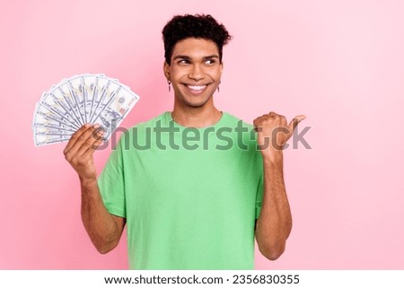 Photo of thoughtful funny man dressed green t-shirt rising cash fan looking thumb empty space isolated pink color background