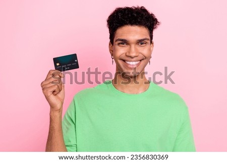 Photo of excited good mood man dressed green t-shirt showing credit card isolated pink color background