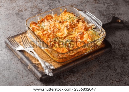 Roasted sweet potato gratin with cheese, eggs and rosemary close-up in a glass baking dish on the table. Horizontal
