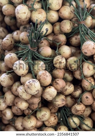 a photography of a pile of potatoes with sprigs of rosemary, grocery store display of potatoes and rosemary sprigs for sale.