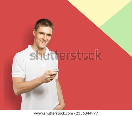Happy young man standing using phone