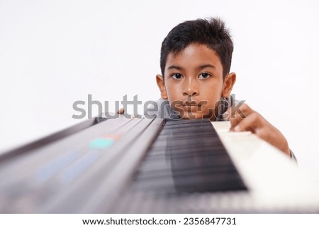 Little boy who are boring with practicing electric piano