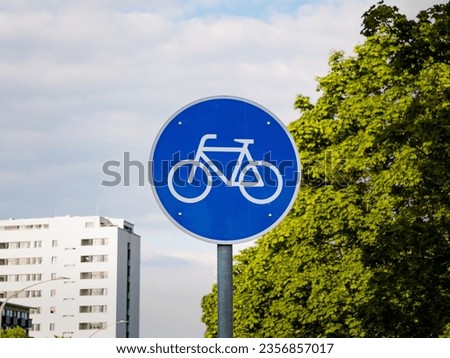 Bicycle path traffic sign in Germany. Close up of the cycle icon on a blue background. The symbol indicates a dedicated way or lane for cyclists next to a road.