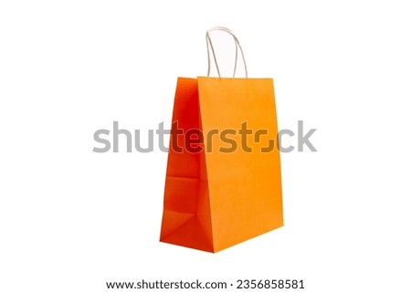 Orange paper bag laying on a white background.