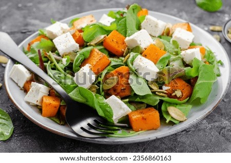 Pumpkin Salad with Arugula, Feta Cheese, and Pumpkin Seeds, Salad Mix with Roasted Pumpkin, Autumn Salad on Dark Background
