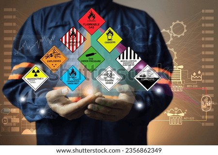Hazardous substance concept chemical safety officer at a dangerous goods warehouse holding hologram to arrange warning sign for different chemical to separate area in sea and air cargo shipment