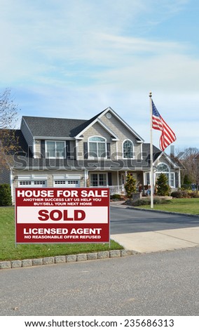 American flag pole Real Estate sold (another success let us help you buy sell your next home) sign curbside suburban Mcmansion house residential neighborhood USA