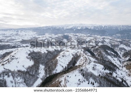 A breathtaking snowy mountain range seen from above Piatra Craiului aerial drone