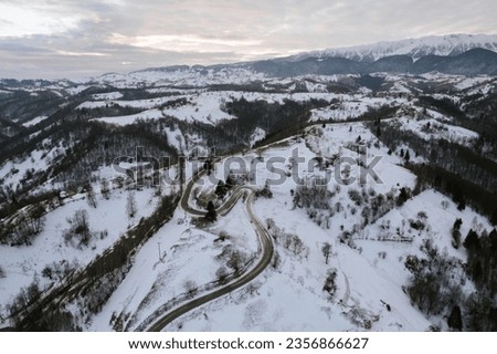 A snow-covered mountain road captured from an aerial perspective Aerial Drone Moeciu Brasov