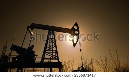 oil industry. silhouette of an oil pump extracts oil and gas from ground of the field. business industry concept. pump pumps oil and gas at sunset. drill petroleum middle industry sunlight
