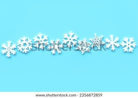 Various wooden snowflakes shape on blue background.