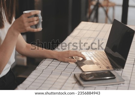 Cropped photo of Freelancer business Asian woman holding coffee cup and at doing planning analyzing the financial report, business plan investment, finance analysis the workplace.