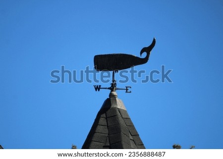 A weathervane in the shape of a whale. Royalty-Free Stock Photo #2356888487
