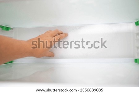 Ice and snow build up on the back wall of the refrigerator. Refrigerator failure, freon leak, temperature sensor defective. Royalty-Free Stock Photo #2356889085