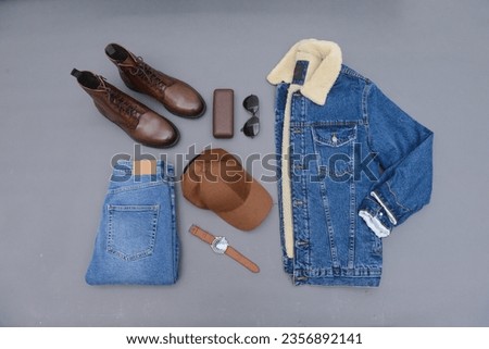 Top view of Man blue jeans and accessories on gray background flat lay Royalty-Free Stock Photo #2356892141