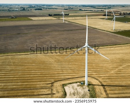 Detailed view of a tall generic wind turbine seen in a farm field in East Anglia, UK. One of a number of wind turbines in view.