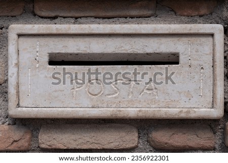 text reads "post" in Italian letterbox rustic old traditional stone post-box in wall rustic letter isolated clear pale craftsmanship 