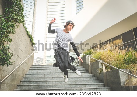 young boy performing parkour movement in the city center