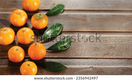 The image shows a couple of oranges and some seedless mandarins sitting on a table. So, the name of the image is Oranges and Seedless Mandarins