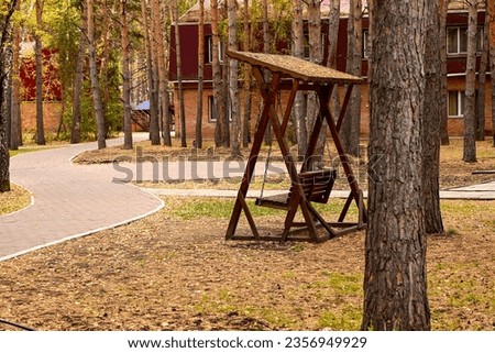 Wooden swing in the autumn forest. The concept of recreation. Autumn landscape.