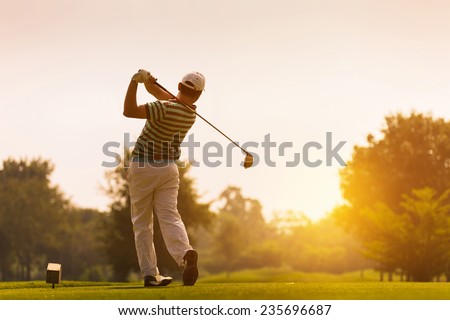 Golfers hit sweeping golf course in the summer Royalty-Free Stock Photo #235696687