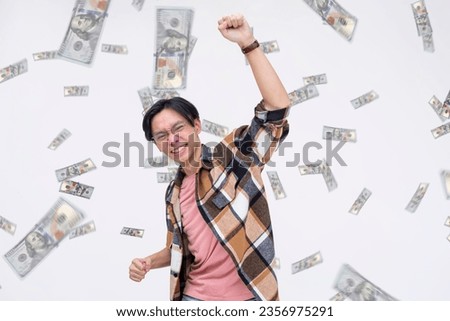 A man celebrating winning a large amount of money. A shower of hundred dollar bills. A lottery or sweepstakes jackpot winner.
