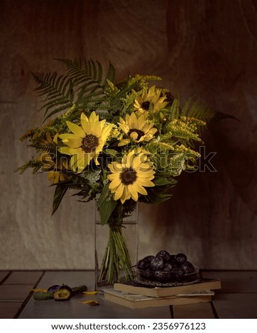 Still life with a bouquet of sunflowers and plums