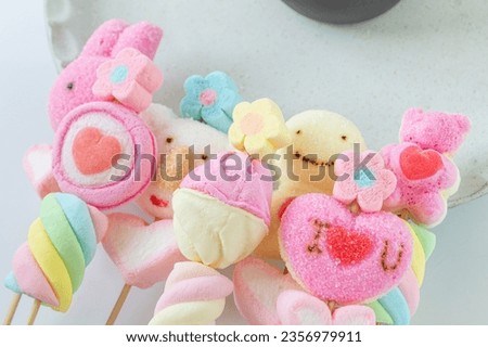 Finishing off with cute, brightly colored marshmallows, soft texture, sweet flavor, a delicious snack on a white background.
