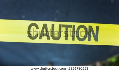 Yellow caution tape on streets symbolizes danger, restriction, and safety measures, warning of hazards or construction sites