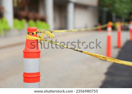 Yellow caution tape on streets symbolizes danger, restriction, and safety measures, warning of hazards or construction sites Royalty-Free Stock Photo #2356980755