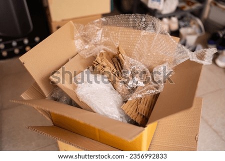 Cardboard box with bubble wrap and kraft paper for packaging Royalty-Free Stock Photo #2356992833
