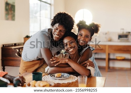 Brazilian family shares a joyful breakfast together, with kids hugging and appreciating their loving mom. Mom and kids feasting at a table filled with delicious homemade pão de queijo.