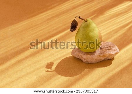 Minimal style composition made of fresh pear with leaf on pastel background with sunlit and shadow. Autumn, fall, thanksgiving day concept.