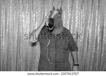 Halloween Photo Booth. Spooky Photo Booth. A man wears a Horse Head and poses while he has his pictures taken in a Haunted Evil Photo Booth of Terror. Haunted Photo Booth. Evil Black and White Photos.