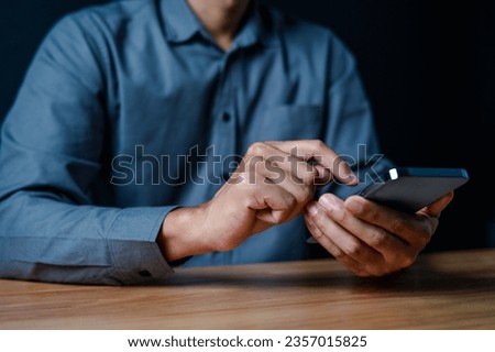 smart phone, close up, people, hand, businessman, portrait, showing, background, blue, equipment. picture is portrait close up to businessman, him hold smart phone and look fixedly at, then play it.