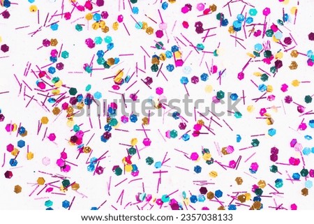 Colorful glitter sparkle confetti background liquid drops of paint color flow down on white canvas. Dark multicolored glitter paint dripping on the white wall