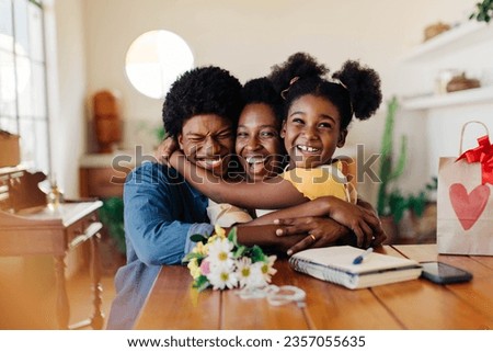 Happy family celebrating together at home. Kids give their mom a bouquet of flowers, bringing joy and love. Special moment showing the beauty of motherhood and the happiness found in simple gestures. Royalty-Free Stock Photo #2357055635