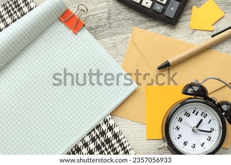 top view of notebook page corner.desk clock.copy space, flat lay. Business and finance concept.